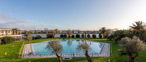 Seasonal outdoor pool, open 10:00 AM to 8:00 PM, pool umbrellas