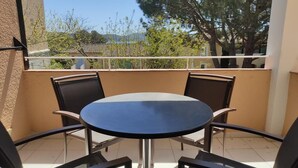 A balcony with a round table and four chairs.