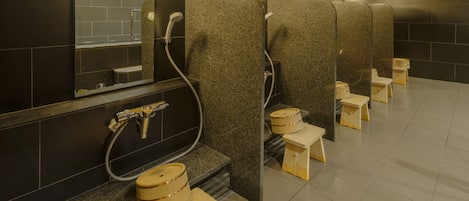 A public restroom with multiple stalls, each with a toilet, a sink, and a mirror.