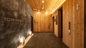 Un couloir d’hôtel aux murs en bois, avec un panneau indiquant l’emplacement du restaurant.