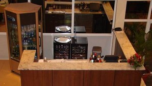 A kitchen with a wooden countertop, a refrigerator, and a window overlooking the interior.