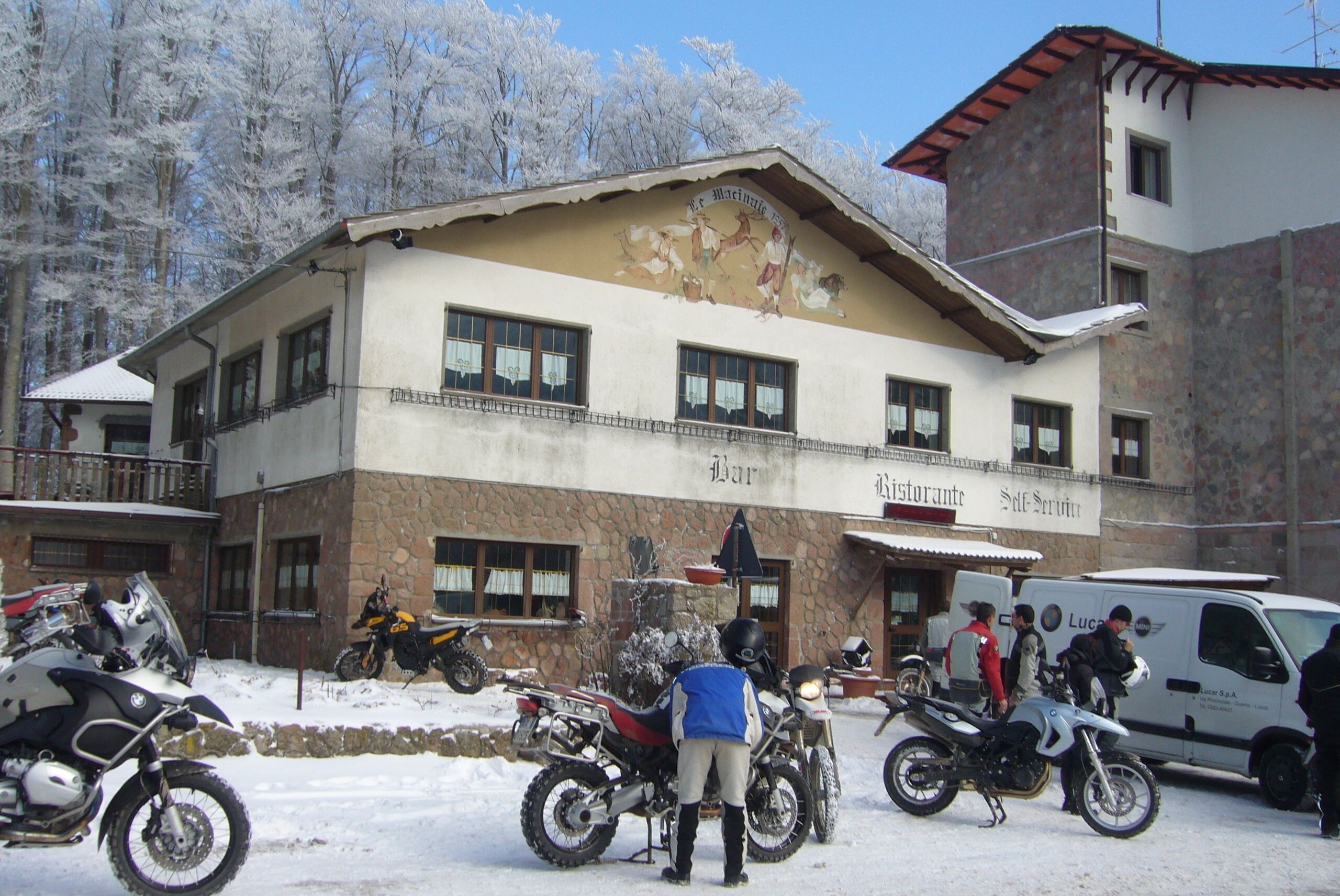 A building with a stone facade, multiple windows, and a mural on the side.