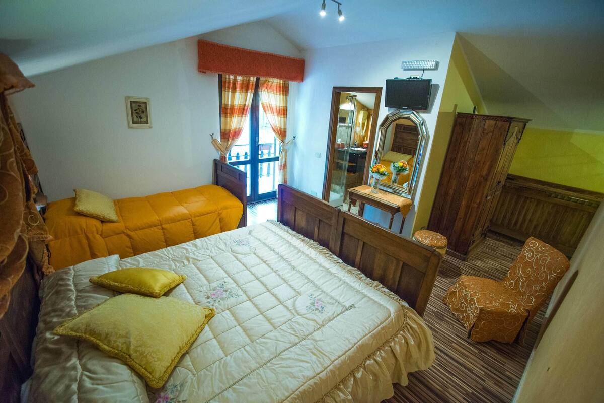 Une chambre à coucher avec un lit, une chaise, un bureau et un miroir.