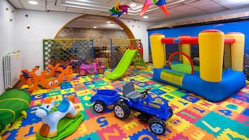 Children can play and explore in this vibrant play area featuring a slide, climbing wall, and ball pit.