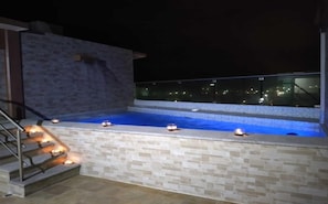 A rooftop pool with a stone wall and a glass balustrade. - Hotel Harbour Inn Veracruz (Veracruz)