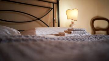Una cama con cabecera, lámpara de noche y una silla.