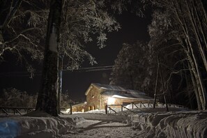 A snow-covered landscape with a wooden cabin and a fence. - Chalet Il Vecchio Rifugio (Castel del Piano)