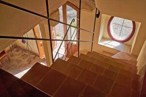 Una escalera con vistas a un patio y una ventana de diseño circular.