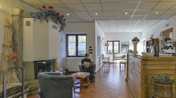 Un ambiente acogedor con chimenea, zona de estar y cocina a la vista.