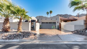 A residential property with a garage, palm trees, and a mountain backdrop. - 222396 3BR Escape w/ Fire Pit: 1 Mi to Old Town (La Quinta)