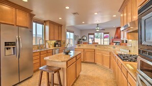 A spacious kitchen with wooden cabinets, stainless steel appliances, and a granite countertop. - 222396 3BR Escape w/ Fire Pit: 1 Mi to Old Town (La Quinta)