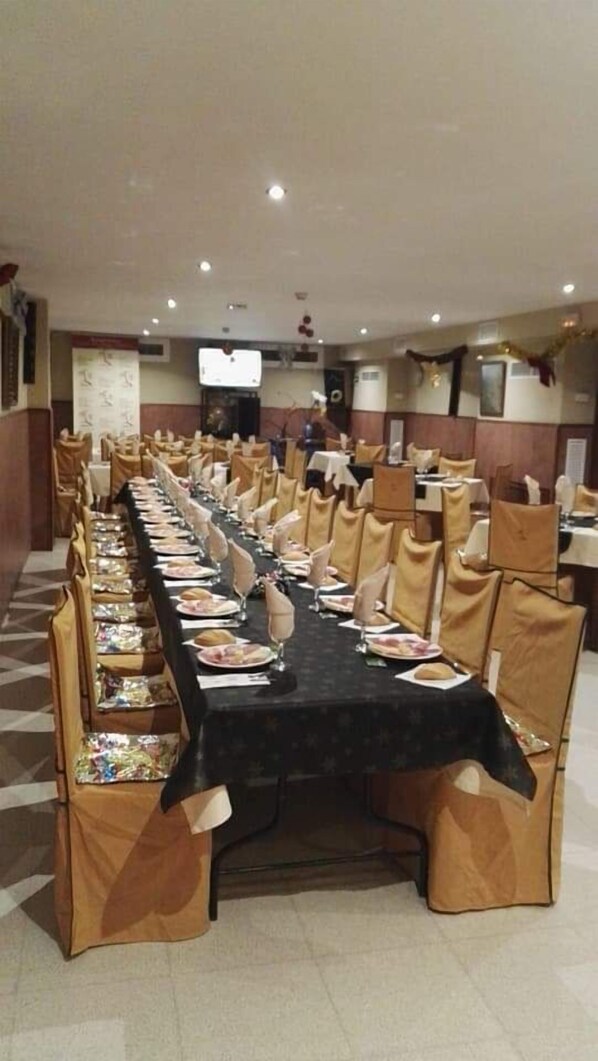 A conference room with a long table set for a meeting, surrounded by chairs.
