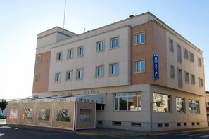 A hotel with a sign reading "HOTEL LA ISLA" and a cafe named "CAFETERIA LA ISLA" on the ground floor.