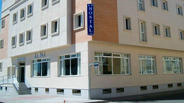 A multi-story building with a sign reading "HOSTAL" on the facade. - Hostal La Isla (Montijo)