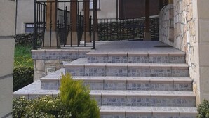 Un espacio al aire libre cubierto con escalones de piedra que conducen a una estructura de madera.