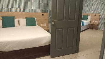 A hotel room with a bed, a nightstand, and a door.