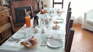 A breakfast table set with plates, glasses, and food items. - B&B Le Mi' Cocche (Capannori)