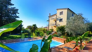 A two-story building with a swimming pool, surrounded by greenery and outdoor furniture. - Apartamento Umag Valica, near the beach with swimming pool, 2 bedrooms, barbecue (Valizza)