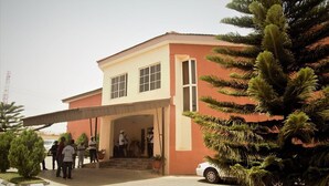 A building with a two-story structure, a covered entrance, and a parking area. - Silk Suites (Jos)