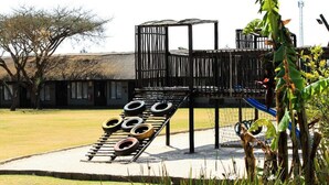 Un área de juegos con una estructura de neumáticos para escalar y un tobogán.