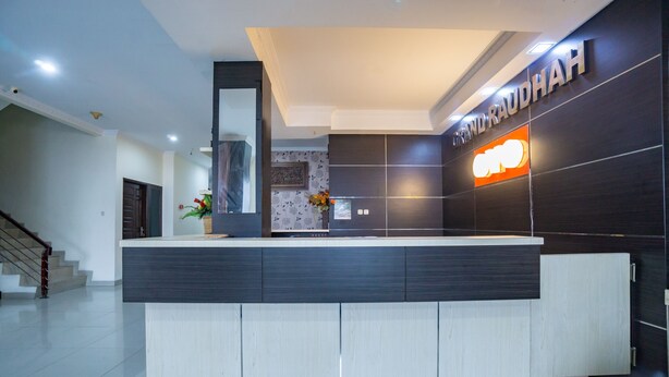 Ein Empfangsbereich im modernen Design mit einer Rezeption, einer Treppe und einem an der Wand befestigten Schild.