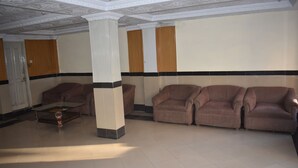 A spacious lobby with a high ceiling, a central column, and two sofas. - Hotel Faran Murree (Murree)