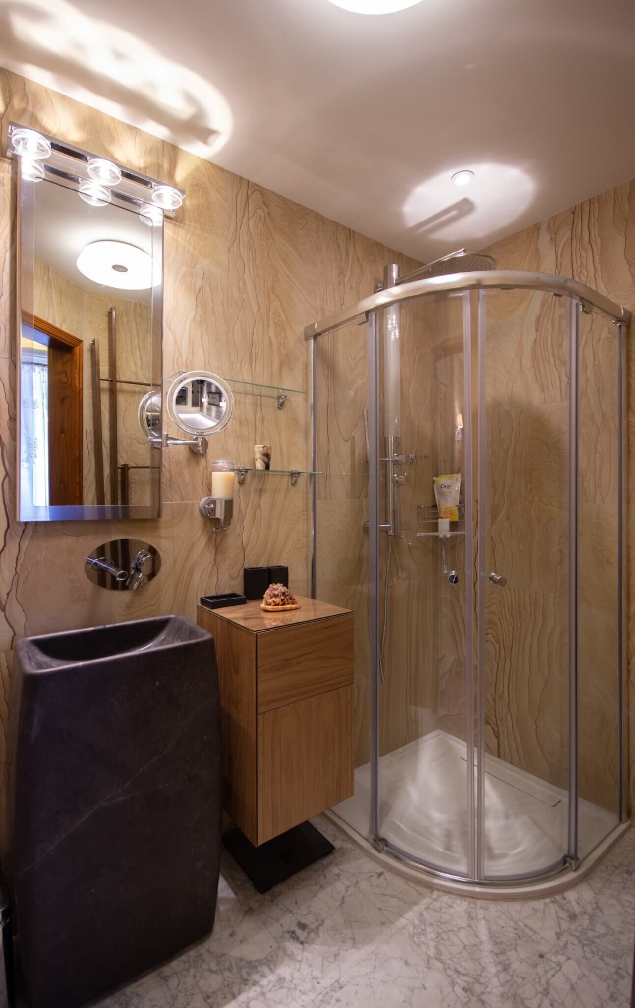 Ein Badezimmer mit Waschtisch, Spiegel, Duschkabine und Waschbecken.