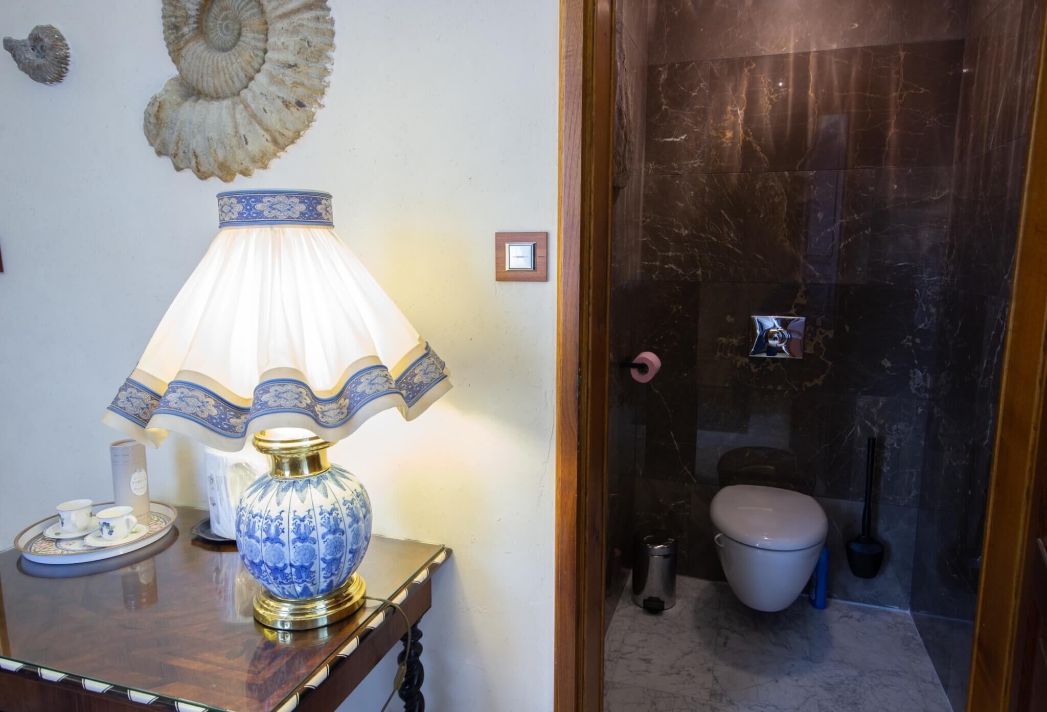 A bathroom with a marble floor, a toilet, a bidet, and a sink.
