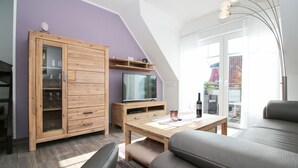 Un salon moderne avec un meuble en bois, un téléviseur et une table à manger.