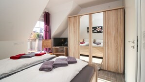 Une chambre moderne avec un lit de style industriel, une télévision et une armoire.