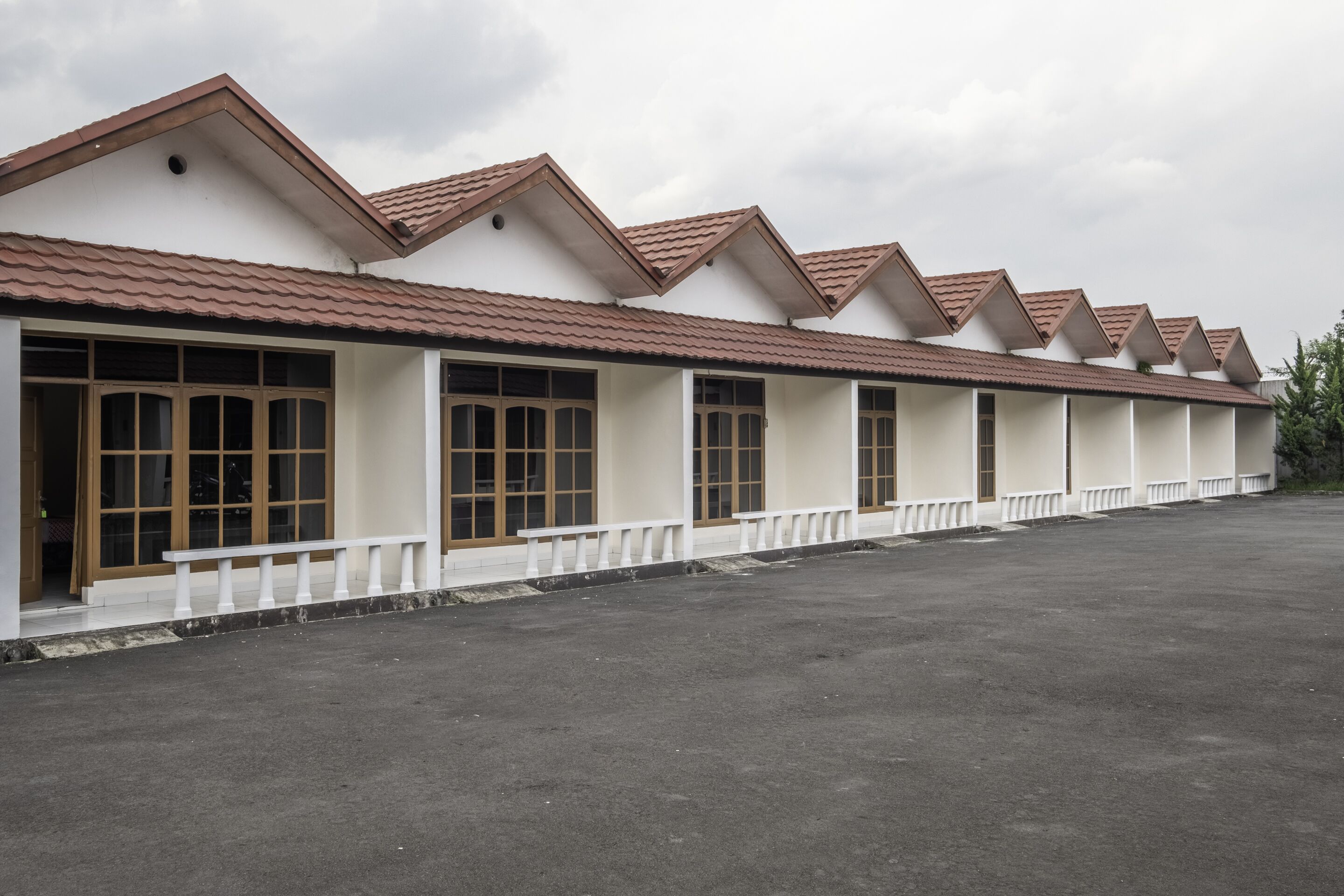 A row of single-story buildings with a consistent architectural style, featuring a tiled roof and large windows.