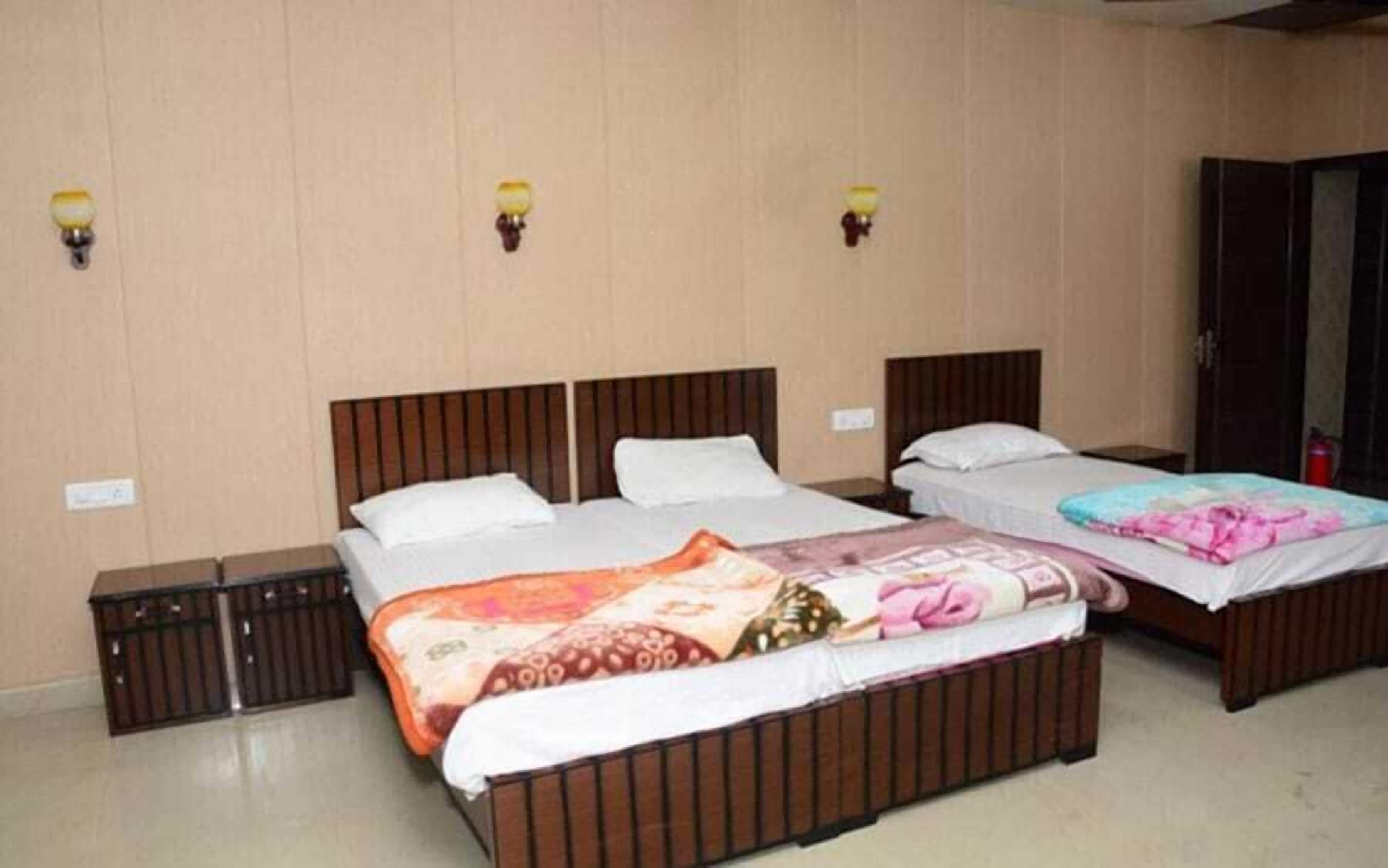 A hotel room with two beds, wooden headboards, and bedside tables.