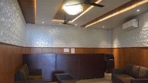 A modern lobby with wooden paneling, a reception desk, and a seating area with sofas and a coffee table. - Krazy Hotel (Haldwani)