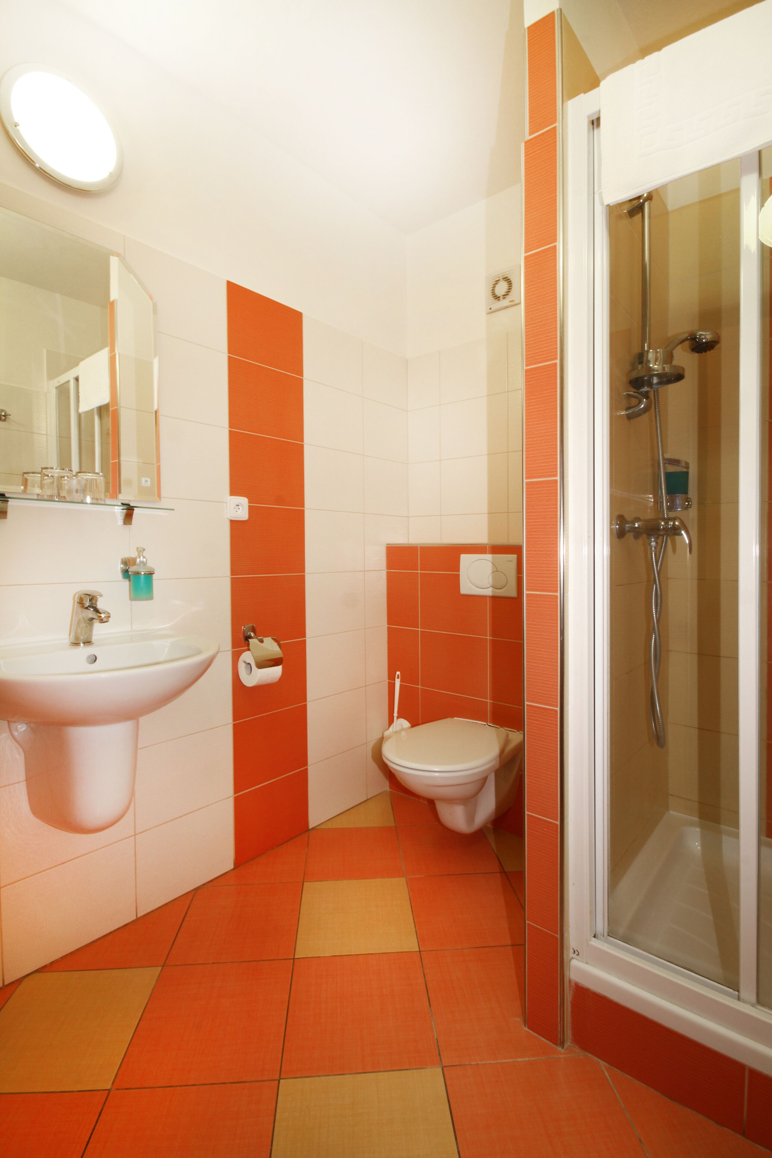 A bathroom with a sink, toilet, and shower.