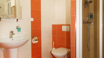 A bathroom with a sink, toilet, and shower.