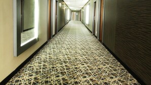 A long hallway with a patterned carpet, recessed lighting, and doors on both sides. - Hotel Strážnice (Straznice)
