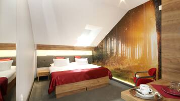A modern hotel room with a large bed, a desk with a cup and saucer, and a mural of a forest scene.