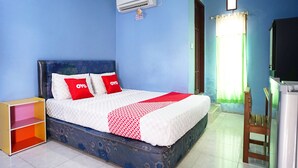 A bedroom with a bed, a wardrobe, a desk, and an air conditioning unit. - OYO 2343 Winolanto Guest House Syariah (Balikpapan)