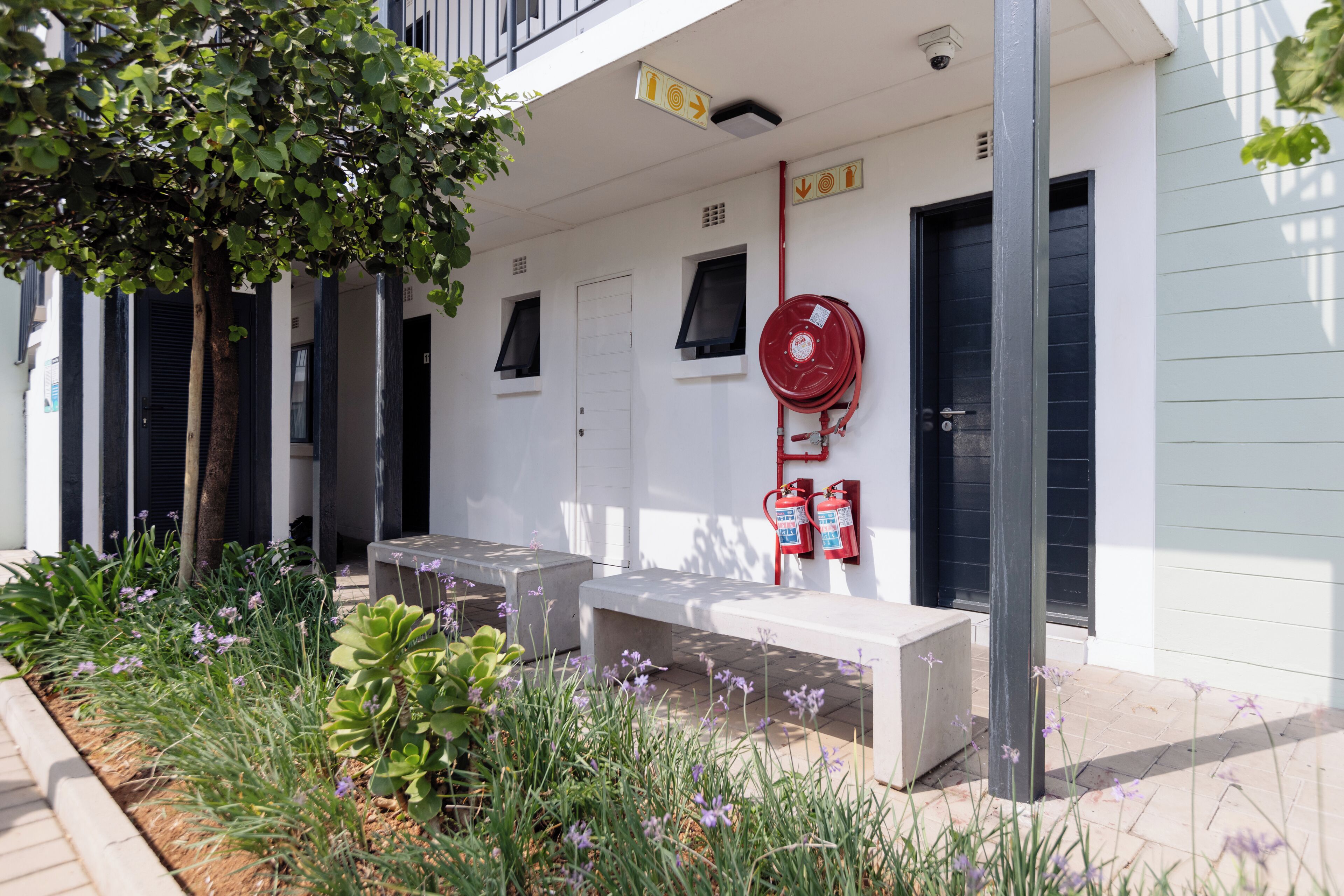 A building with a fire hose, a door, and a window.