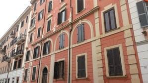Um edifício com várias andares, janelas em arco e varandas.