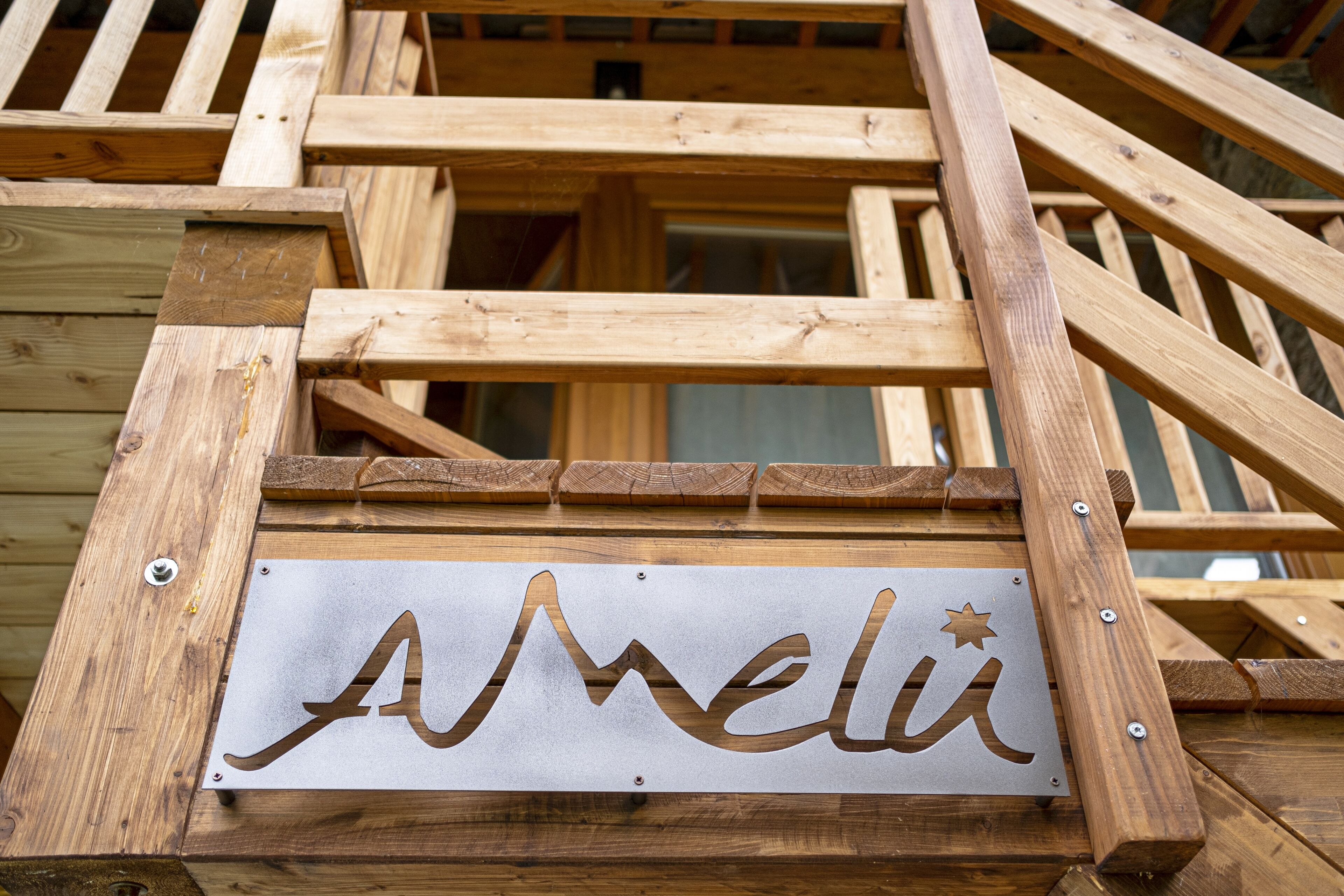 A wooden staircase with a sign that reads "Meli" and a star symbol.
