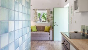 Eine kleine Küche mit einer Holzauskładung, einem eingebauten Backofen und einem Fenster mit Vorhängen.