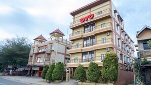 Um hotel com vários andares, varandas e um letreiro 'OYO' bem visível.