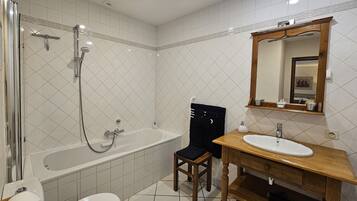 A bathroom with a bathtub, toilet, and sink.