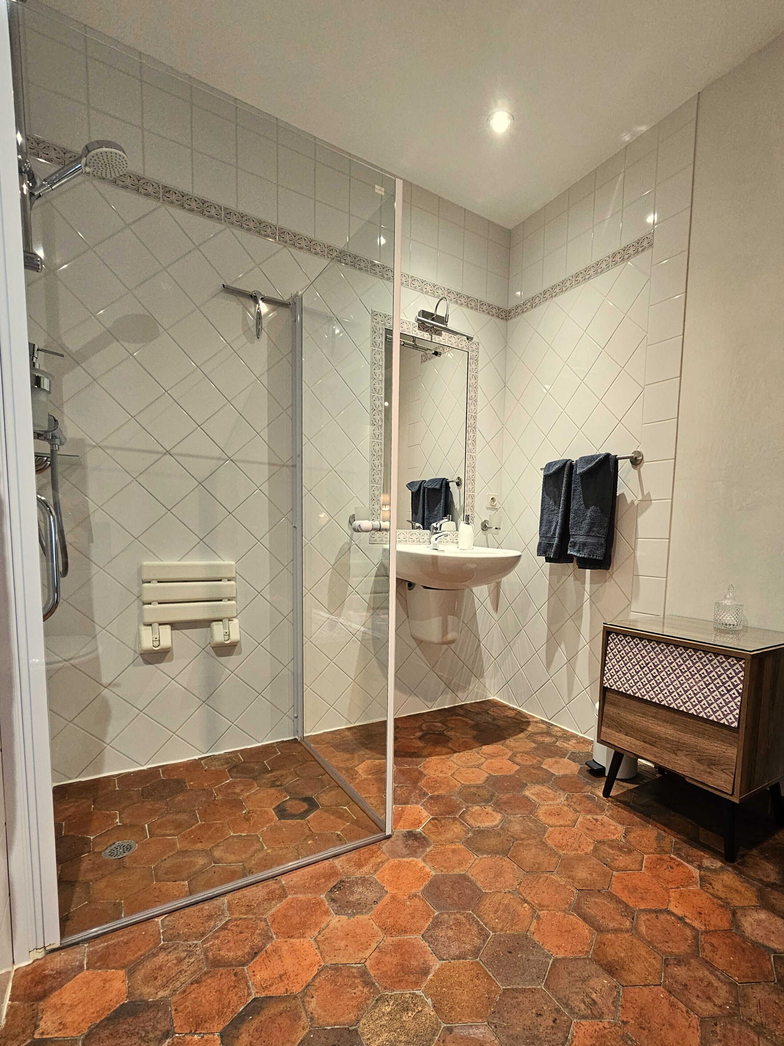 A bathroom with a shower, a sink, and a vanity.