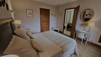 Quarto com cama, mesas de cabeceira, espelho e porta.