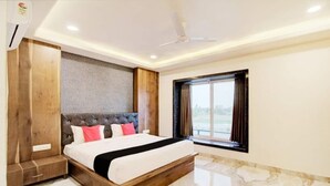 Un dormitorio moderno con una cama grande, un armario de madera y una ventana con cortinas.