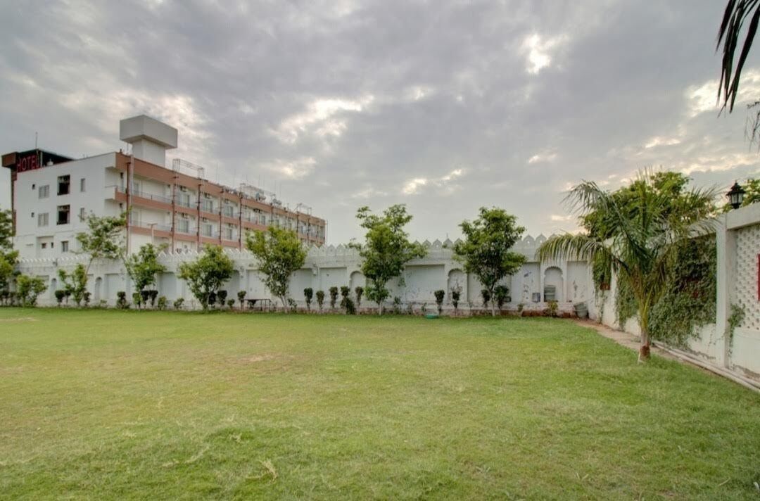 A hotel with a courtyard, multiple floors, and a white exterior.