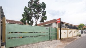 Un hôtel entouré de murs, avec une enseigne indiquant qu’il s’agit de l’« hôtel Brosta ».