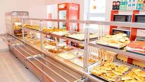 Ein Buffet mit verschiedenen Speisen und einem Coca-Cola-Kühlschrank.
